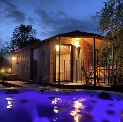 什鲁斯伯里Riverside Cabins的一座小房子,晚上有游泳池