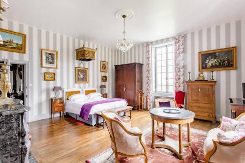 Fleurigné蒙特布劳而特庄园酒店的卧室配有一张床和一张桌子及椅子