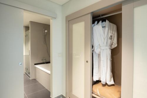 阿尔贝诺阿Vila Gale Collection Monte do Vilar的浴室设有衣柜和白色毛巾。