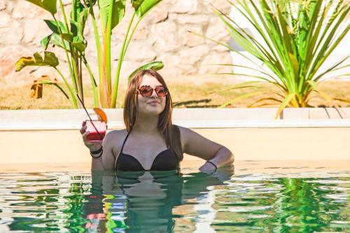 科林比亚Delfinia Resort - All Inclusive的游泳池里的女人喝一杯