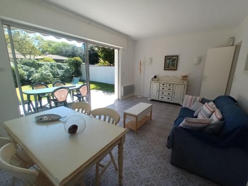 拉特斯特德布赫Pyla-sur-mer maison 2 chambres et jardin - à 400m des plages的客厅配有蓝色的沙发和桌子