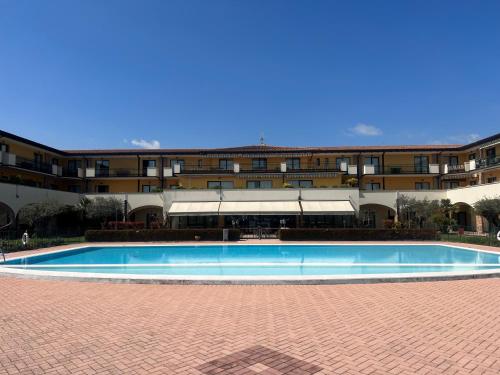 加达湖畔帕登赫Le Terrazze sul Lago Hotel & Residence的大楼前的大型游泳池