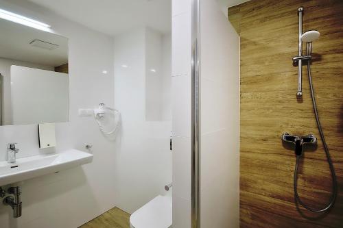 赫尔Hotel Hel的带淋浴、卫生间和盥洗盆的浴室