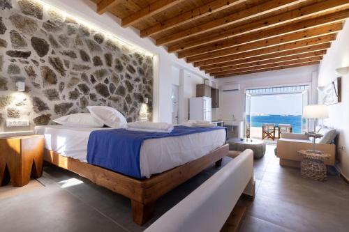 基莫洛斯岛Ωκεανίς Κίμωλος的一间卧室设有一张大床和石墙