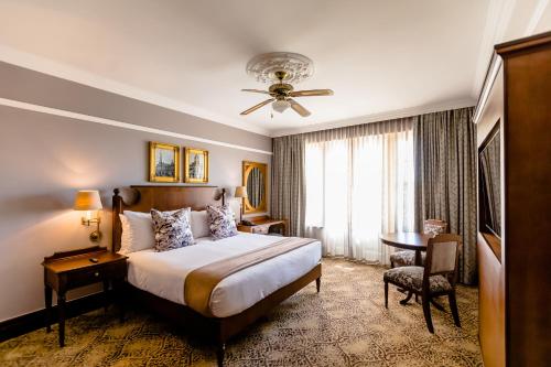 约翰内斯堡Gold Reef City Hotel的配有一张床、一张书桌和一扇窗户的酒店客房