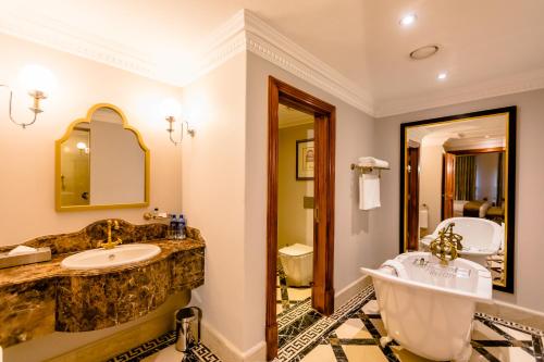 约翰内斯堡Gold Reef City Hotel的浴室配有2个盥洗盆和1个浴缸。