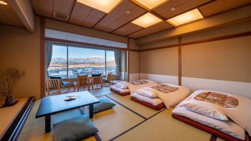 松本onsen hotel OMOTO的一间设有两张床和一张桌子的房间