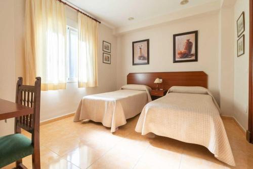 卡萨韦梅哈雄鸡酒店的一间卧室设有两张床和窗户。