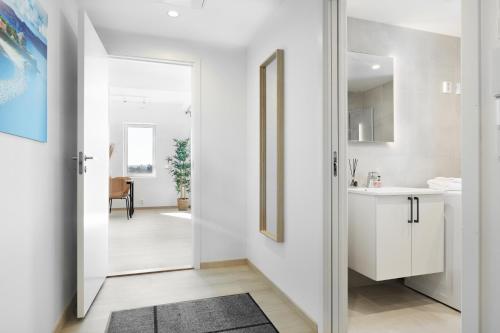 特隆赫姆Forenom Serviced Apartments Trondheim的一条带白色墙壁的走廊和一扇通往浴室的门