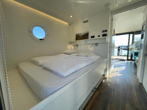 坎珀兰Houseboat Kamperland的窗户客房内的一张大白色床
