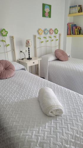 厄尔-汝姆披多Mi casita playera的一间卧室配有两张床和白色的被子