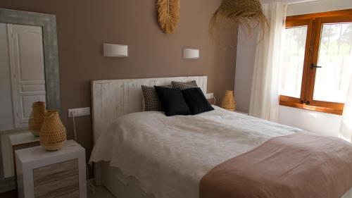 哈维亚Villa Sal y Mar - Jávea ! Freshly Renovated !的一间卧室配有一张带黑色枕头的床和一扇窗户。