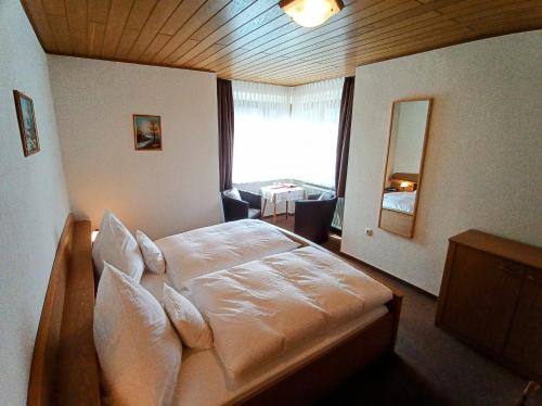 吕德斯海姆Pension Milberg Assmannshausen的一间卧室设有一张大床和大窗户