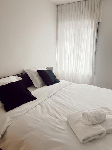 伊普尔Vakantiewoning number 44的一张白色的床,上面有两条毛巾
