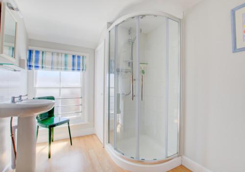 绍斯沃尔德54 Stradbroke Road的一间带玻璃淋浴和水槽的浴室