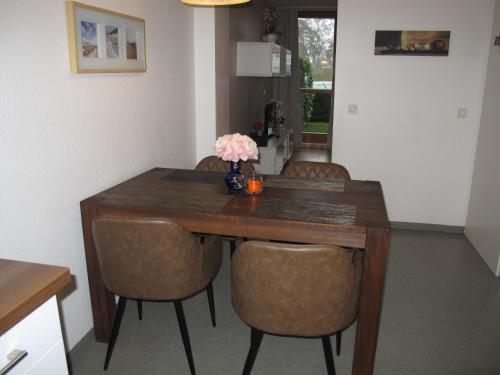 卢布明Holiday Home Strandvilla - LUB117 by Interhome的一张带椅子的木桌和花瓶