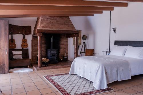莱里亚Casa do Lume的一间卧室配有一张床和一个砖砌壁炉