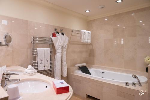 沃纳斯乔治布兰克酒店&Spa的带浴缸、水槽和浴缸的浴室
