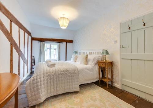 拉文纳姆Coppers的一间卧室配有一张床、一张桌子和一个窗户。