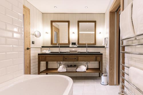 施伦斯蒙塔丰鲁汶酒店的带浴缸、水槽和镜子的浴室