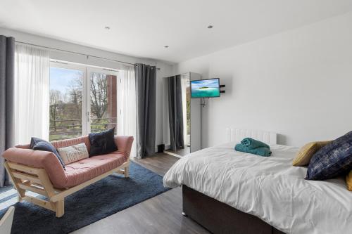 埃克塞特Exeter City Centre Apartments Eden Apartment的一间卧室配有一张床、一把椅子和电视
