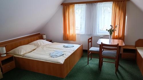 佩尔赫日莫夫Motel Velký Rybník的卧室配有一张床和一张桌子及椅子