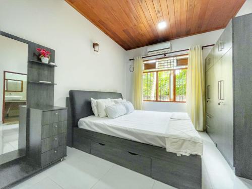 贝鲁沃勒Ceylon Serenity Villa的一间卧室设有一张大床和一个窗户。