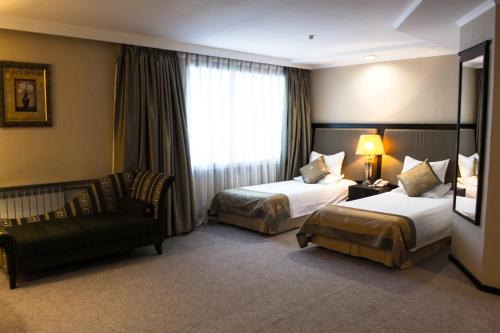 乌斯季卡缅诺戈尔斯克Shiny River Hotel的酒店客房,设有两张床和一张沙发