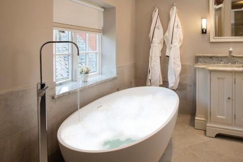 彻特西Foxhills Club & Resort的带窗户的浴室内的白色浴缸