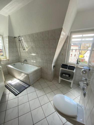 利希滕斯泰因Geräumiges Stadtapartment的白色的浴室设有浴缸和水槽。