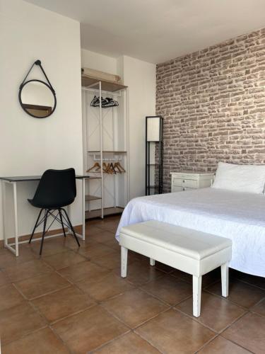 圣何塞阿罗哈旅馆的一间卧室配有一张床、一张桌子和一把椅子