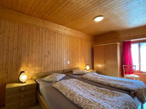 RossaApartment Casa della Posta-2 by Interhome的木墙客房的两张床