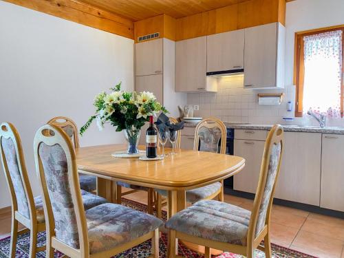 RossaApartment Casa della Posta-2 by Interhome的厨房配有桌椅和一瓶葡萄酒