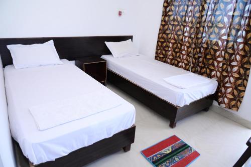 菩提伽耶Dwarka Home Stay的一间带两张床的卧室和地毯