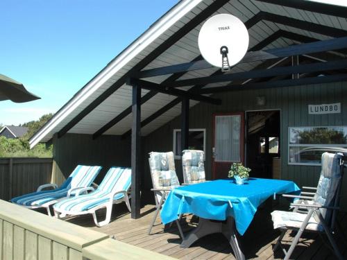 瓦伊厄斯斯特兰德Holiday Home Nilda - 1km from the sea in Western Jutland by Interhome的房屋内带蓝色桌椅的甲板