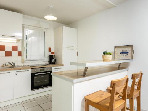 普勒尔蒂Apartment Les Caps Horniers by Interhome的厨房配有白色橱柜和桌椅