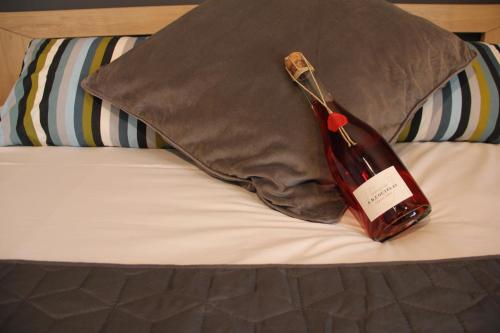 迪斯路易斯维克多住宿加早餐旅馆的床上坐着一瓶葡萄酒