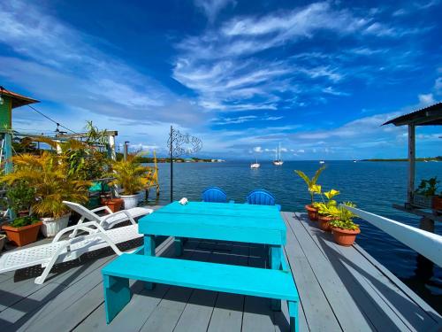 博卡斯德尔托罗Saigon Bay Bed & Breakfast的坐在水边甲板上的蓝色长椅