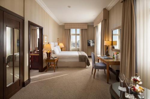 萨格勒布摄政萨格勒布休闲酒店的配有一张床和一张书桌的酒店客房