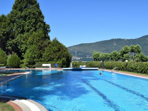 波尔托瓦尔特拉瓦利亚Holiday Home Villa Camelia by Interhome的一个种满树木和山脉的大型蓝色游泳池