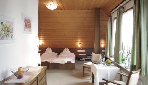 舍姆贝格奥赫森兰德加特酒店的卧室配有一张床和一张桌子及椅子