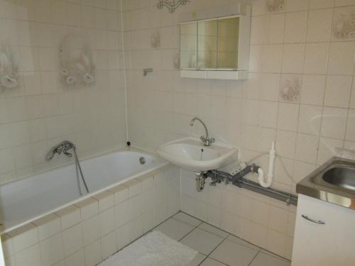 施韦青根Mainzer Rad的浴室配有盥洗盆、浴缸和盥洗盆