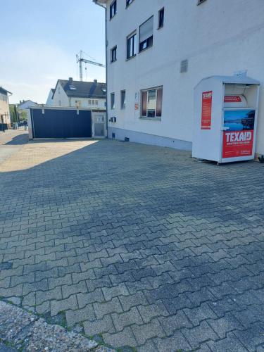施韦青根Mainzer Rad的白色建筑旁边的砖砌停车场