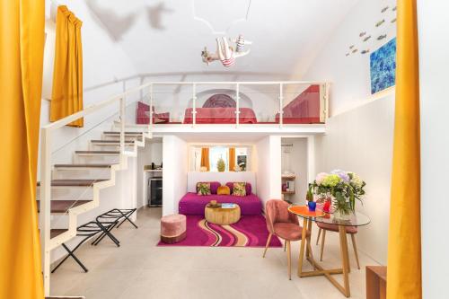 卡普里Suite Belvedere Capri Exclusive Rooms的客厅配有紫色沙发和楼梯