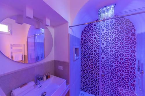 卡普里Suite Belvedere Capri Exclusive Rooms的带淋浴、盥洗盆和镜子的浴室