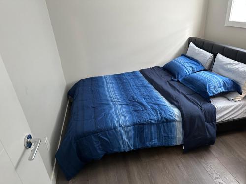 萨斯卡通Cozy BSMT Apt w/2BR+Disney+ Nflx的一张带蓝色床单和枕头的床