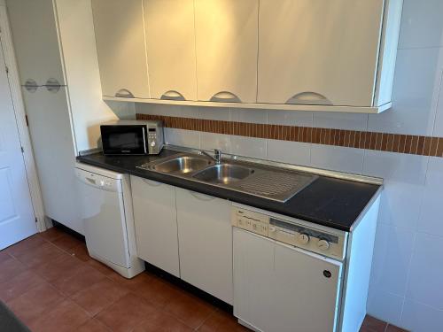 阿尔豪林格朗德Luxurious 3 Bedroom Apartment in the heart of Alhaurín Golf的一间带水槽和微波炉的小厨房