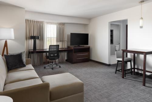 拉戈Residence Inn Largo Medical Center Drive的客厅配有沙发和书桌及电视