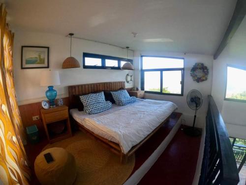 AngonoDicimulacion Staycation House的一间卧室配有一张带蓝色枕头的床。
