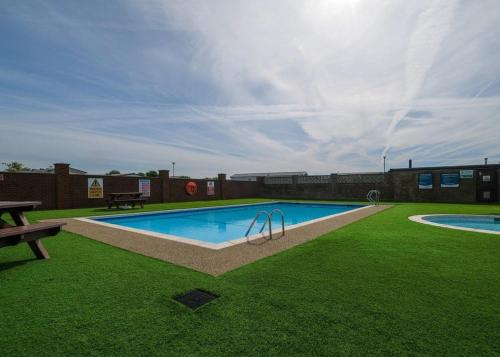 科克勒姆Cockerham Sands的一个带长凳和草地的庭院内的游泳池
